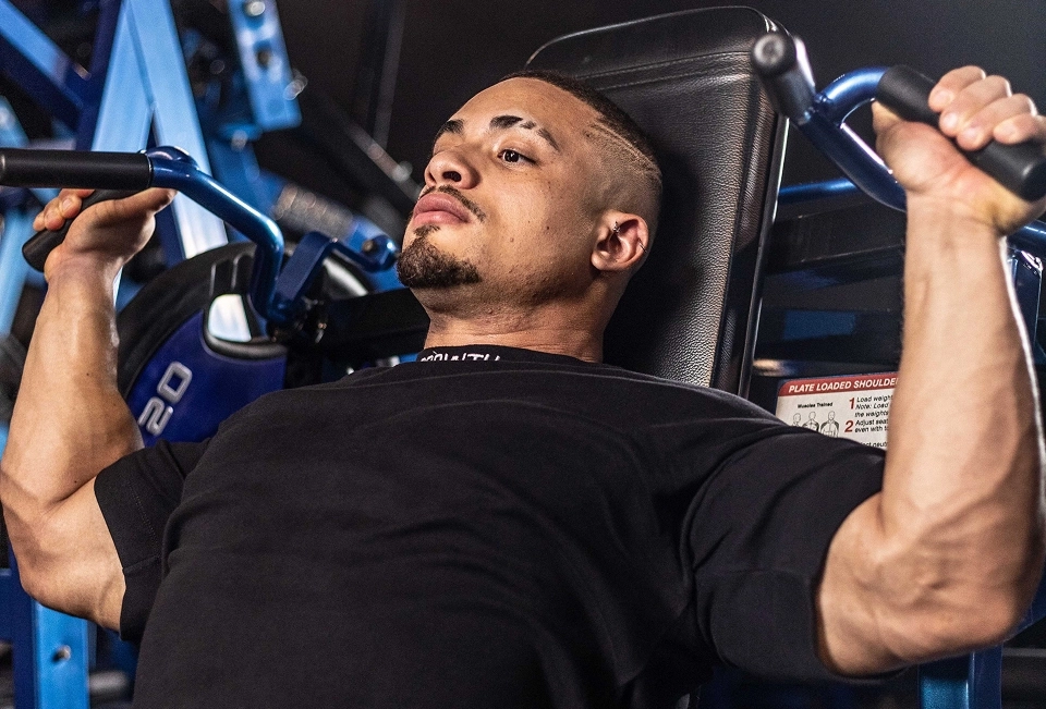 Gnomo Atleta Growth Supplements fazendo exercícios dentro de uma academia